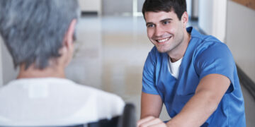 A person in a blue shirt talking to a person Description automatically generated with low confidence